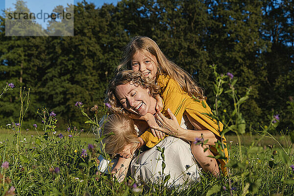 Glückliche Mutter genießt mit ihren Töchtern das Blumenfeld