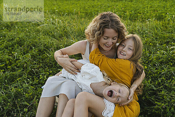 Glückliche Mutter genießt es mit ihren Töchtern im Gras