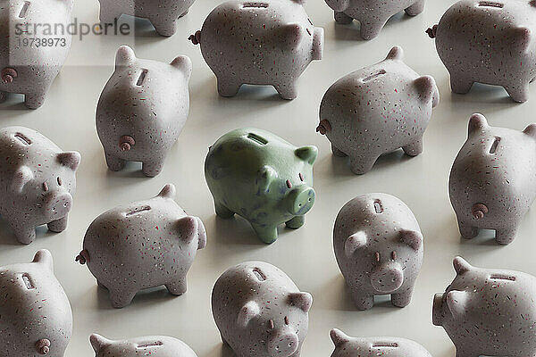 Green piggy bank with many piggy banks over white background