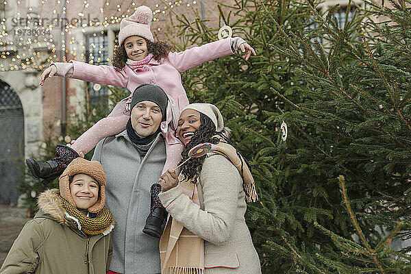 Glückliche Familie  die zusammen Spaß in der Nähe des Weihnachtsbaums hat