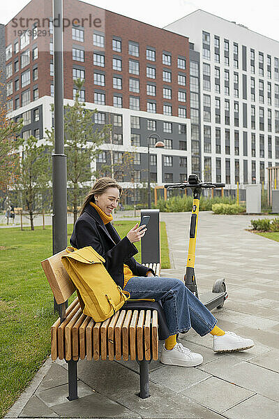 Glückliche Frau  die im Park per Videoanruf über ihr Smartphone spricht