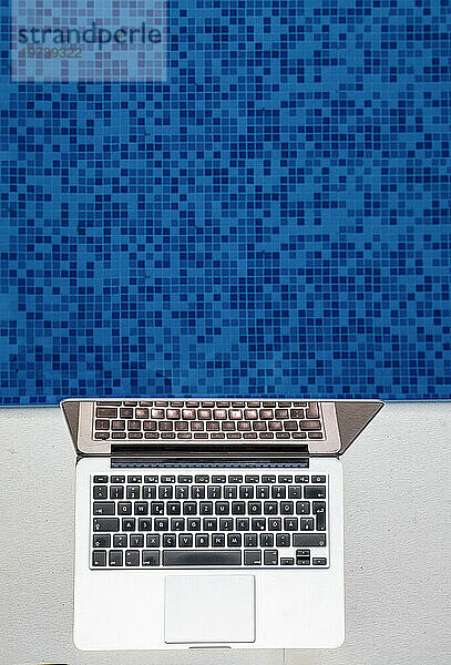 An sonnigen Tagen wird der Laptop in der Nähe des blauen Swimmingpools aufbewahrt