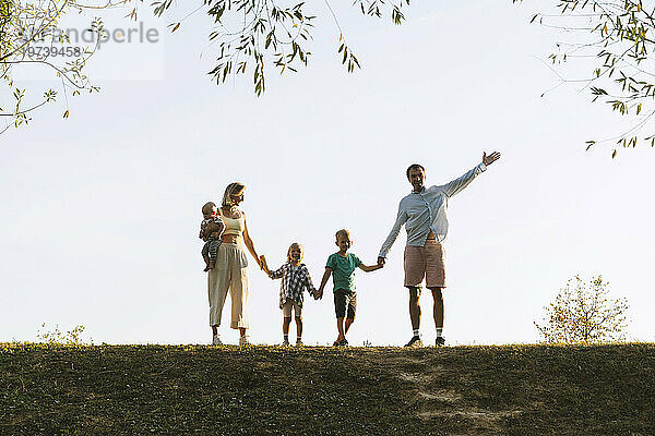 Glückliche Familie hält Händchen und steht im Park