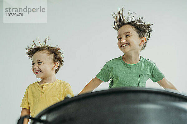 Happy children having fun in front of white wall