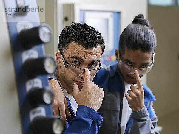 Junge Auszubildende tragen Schutzbrillen in der Werkstatt