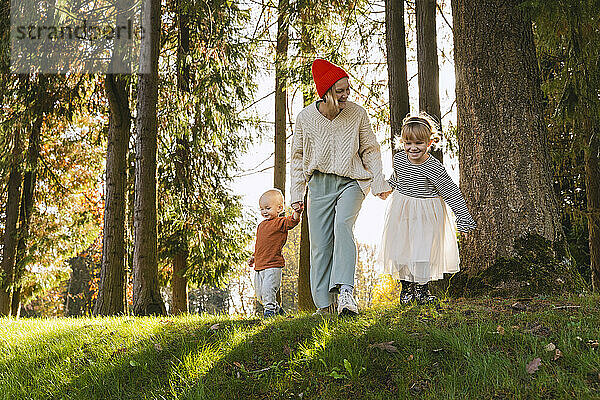 Glückliche Familie  die Spaß in der Nähe von Bäumen im Wald hat