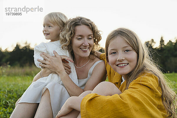 Lächelnde Mutter und Töchter verbringen ihre Freizeit miteinander