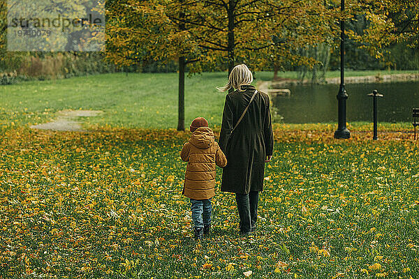Mutter und Sohn gehen im Herbstpark spazieren