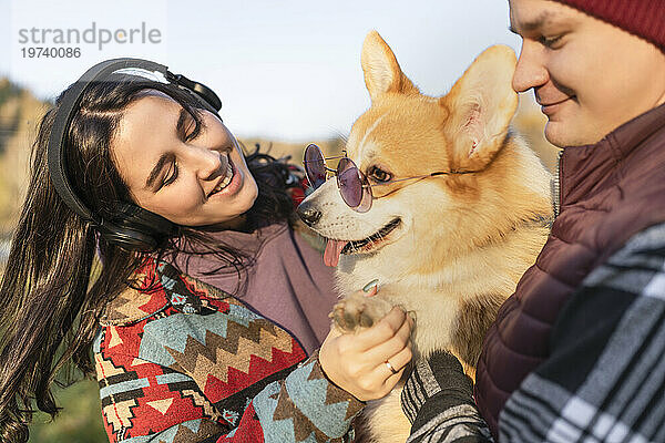 Paar mit Hund und Sonnenbrille am Wochenende im Park