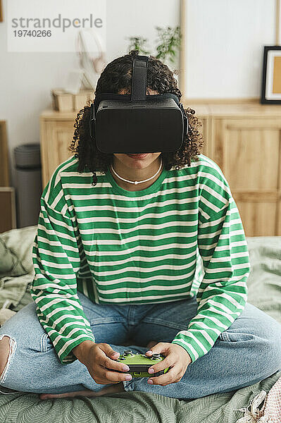 Mädchen trägt Virtual-Reality-Simulatoren und spielt zu Hause ein Videospiel mit einem Controller