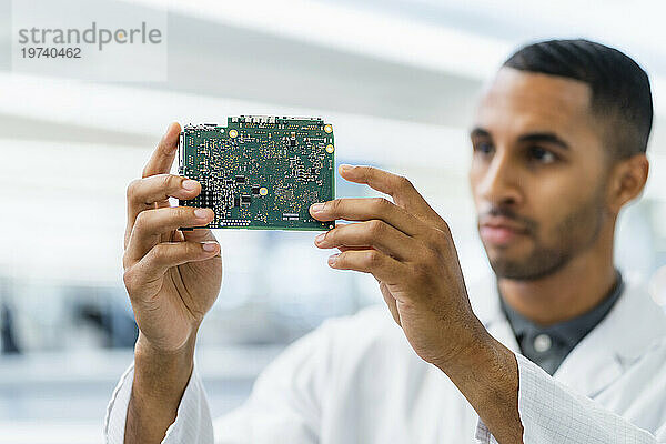 Electrical technician looking at motherboard
