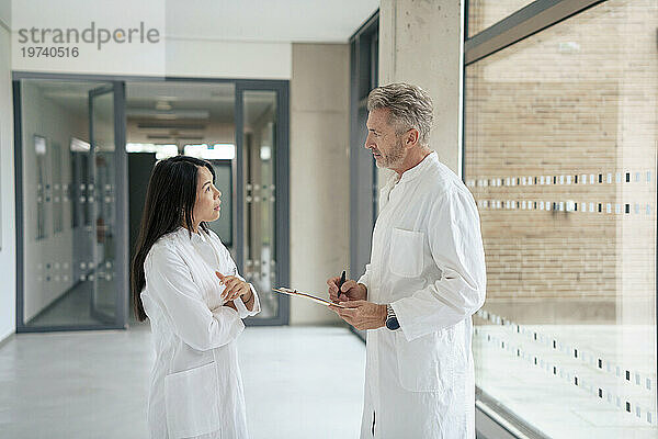 Wissenschaftler diskutieren gemeinsam im Laborkorridor