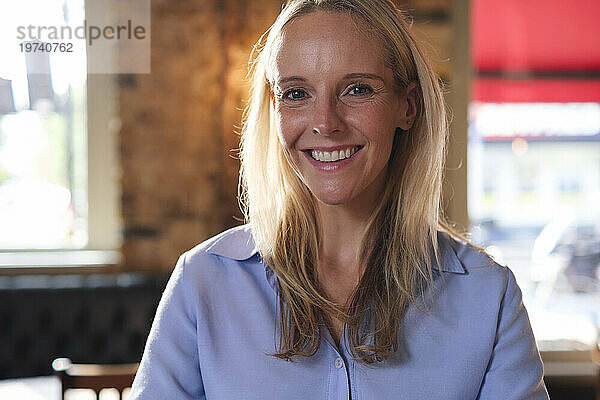 Smiling blond businesswoman in cafe