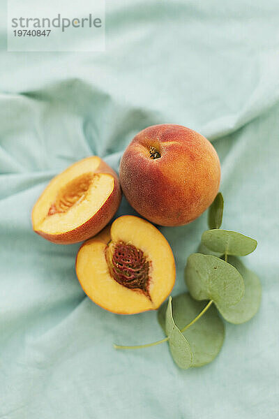 Ripe peaches on green fabric