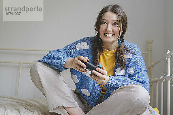 Glückliches Mädchen  das zu Hause Videospiel mit Controller spielt