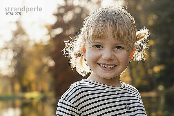 Smiling cute blond girl on sunny day