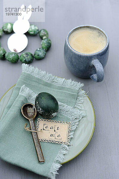 Easter eggs  napkin  teaspoon with label and mug of coffee