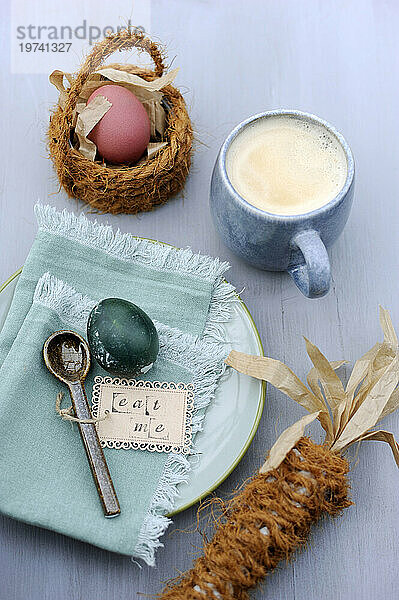 Easter eggs  napkin  teaspoon with label and mug of coffee