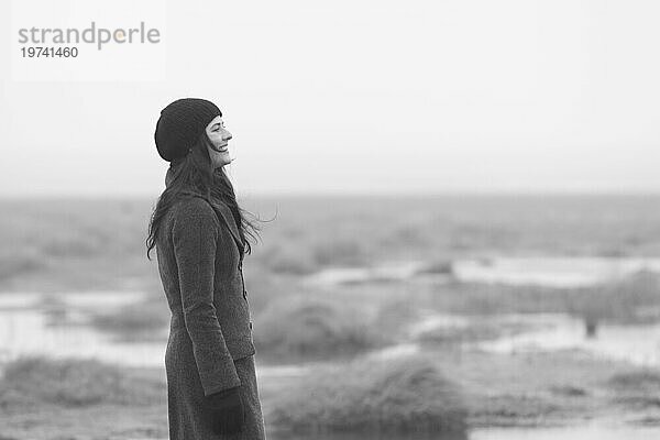 Frau steht im Nebel  in einem Gezeitengebiet der Insel Schiermonnikoog mit Blick auf die Nordsee  Niederlande