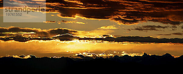 Dramatisch leuchtender Himmel über einer silhouettierten Bergkette; Surrey  British Columbia  Kanada
