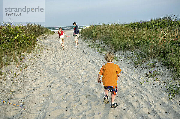 Drei Geschwister an einem weißen Sandstrand an der Küste; Stone Harbor  New Jersey  Vereinigte Staaten von Amerika
