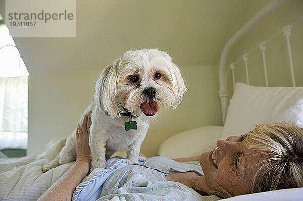 Frau liegt mit ihrem Hund zu Hause im Bett; Lincoln  Nebraska  Vereinigte Staaten von Amerika