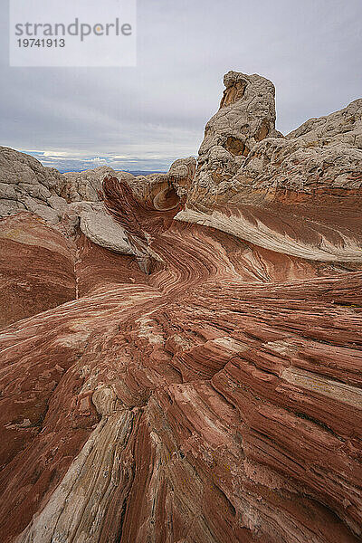 Malerische Aussicht auf wirbelnde Muster und hügelige Felsformationen unter einem wolkigen Himmel  die Teil der fremden Landschaft mit erstaunlichen Linien  Konturen und Formen in der wundersamen Gegend namens White Pocket in Arizona sind; Arizona  Vereinigte Staaten von Amerika