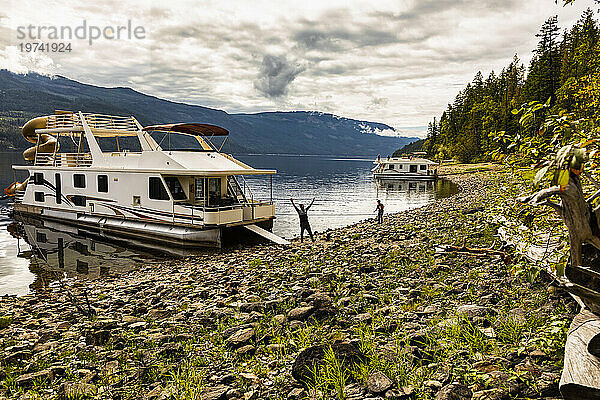 Eine Familie genießt einen Hausbooturlaub  während sie am Ufer des Shuswap Lake parkt; Shuswap Lake  British Columbia  Kanada