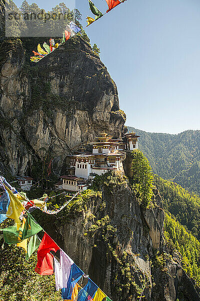 Gebetsfahnen überspannen den Abgrund vor dem Tigernest-Kloster in Bhutan; Paro  Bhutan