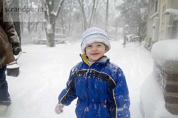 Kleiner Junge spielt draußen im Schneesturm; Lincoln  Nebraska  Vereinigte Staaten von Amerika