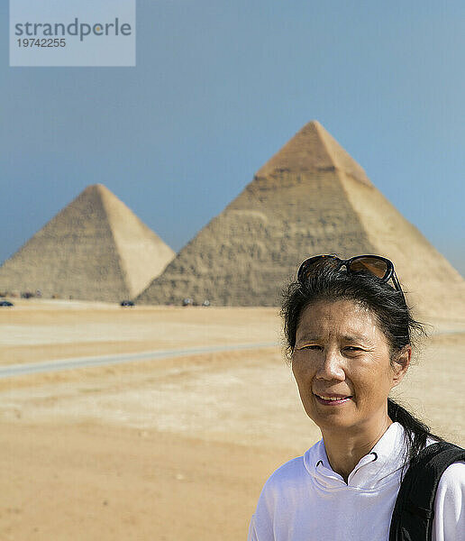 Nahaufnahme einer asiatischen Touristin  die vor den Großen Pyramiden von Gizeh steht; Gizeh  Kairo  Ägypten