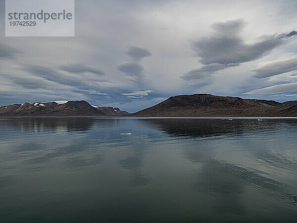 Bewölkter Himmel über Spitzbergen und das ruhige Wasser des Sunds; Spitzbergen  Svalbard  Norwegen