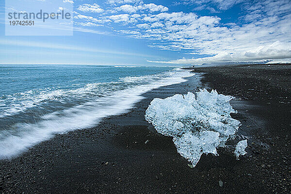 Kleiner Eisberg vom Vatnajökull am Ufer eines schwarzen Sandstrandes; Island