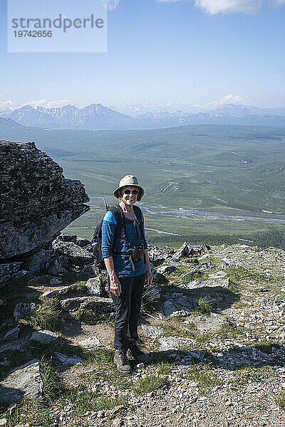 Porträt einer reifen Wanderin auf dem Savage Alpine Trail mit Blick auf den Mt. Denali im Denali-Nationalpark; Denali-Nationalpark  Alaska  Vereinigte Staaten von Amerika