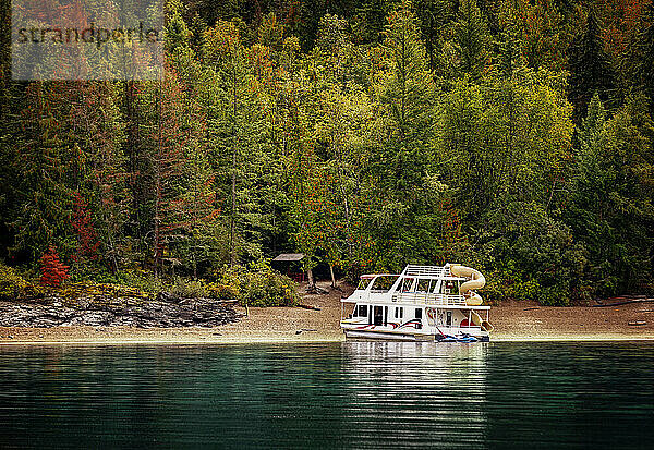 Ein Ferienhausboot  das im Herbst am Ufer des Shuswap Lake geparkt ist; Shuswap Lake  British Columbia  Kanada