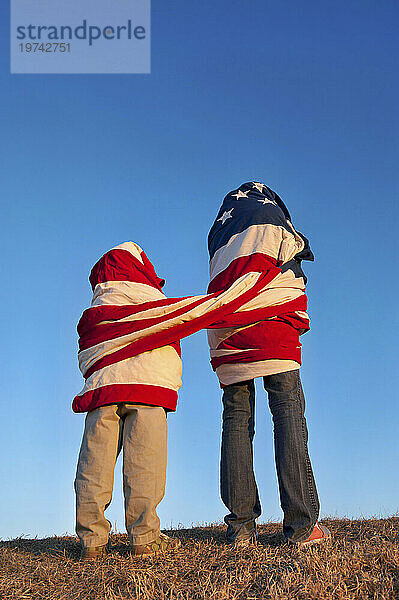 Zwei Menschen  die zusammen in eine amerikanische Flagge gehüllt sind; Lincoln  Nebraska  Vereinigte Staaten von Amerika