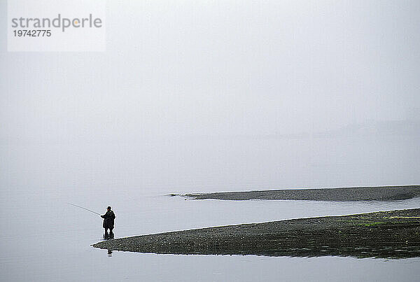 Einsamer Fischer beim Angeln an einer nebligen Küste; Orleans  Cape Cod  Massachusetts  Vereinigte Staaten von Amerika