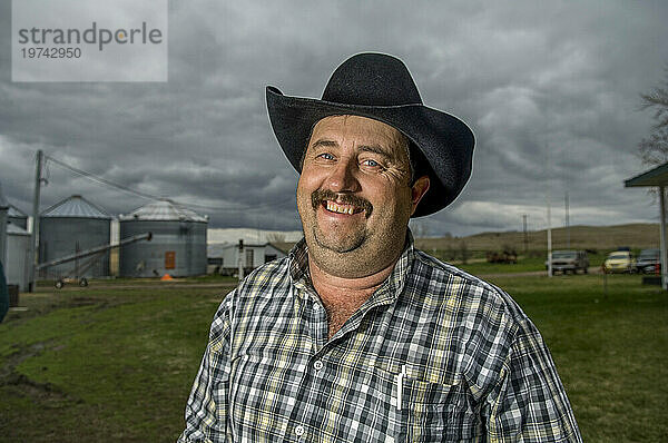 Porträt eines lächelnden Cowboys auf seiner Farm; Burwell  Nebraska  Vereinigte Staaten von Amerika