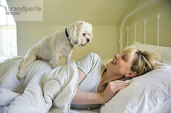 Frau liegt mit ihrem Hund zu Hause im Bett; Lincoln  Nebraska  Vereinigte Staaten von Amerika