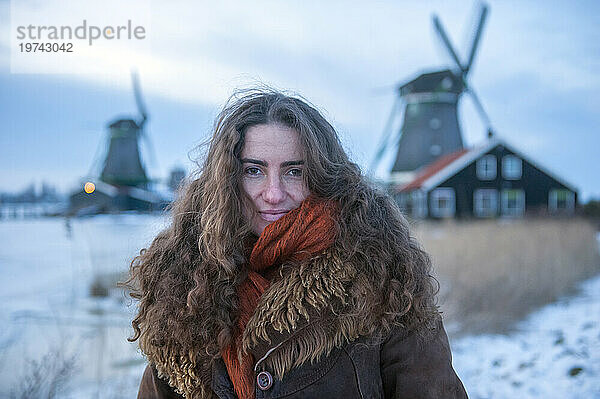 Junge Frau posiert in Zaanse Schans  einem historischen Windmühlengebiet in den Niederlanden; Amsterdam  Niederlande