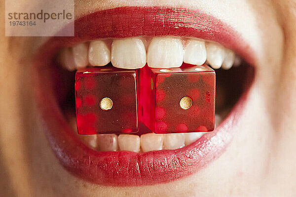 Woman holds two dice between her lips; Lincoln  Nebraska  United States of America