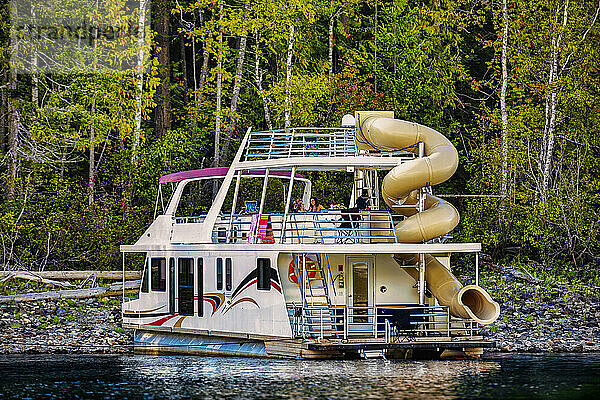 Eine Familie genießt einen Hausbooturlaub  während sie am Ufer des Shuswap Lake parkt; Shuswap Lake  British Columbia  Kanada