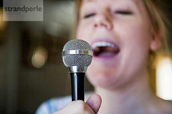 Junge Frau singt mit Mikrofon ein Lied; Lincoln  Nebraska  Vereinigte Staaten von Amerika