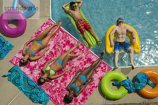 Blick direkt von oben auf eine Gruppe junger erwachsener Freunde  die an einem heißen Tag die Zeit am Pool genießen; Virginia Beach  Virginia  Vereinigte Staaten von Amerika