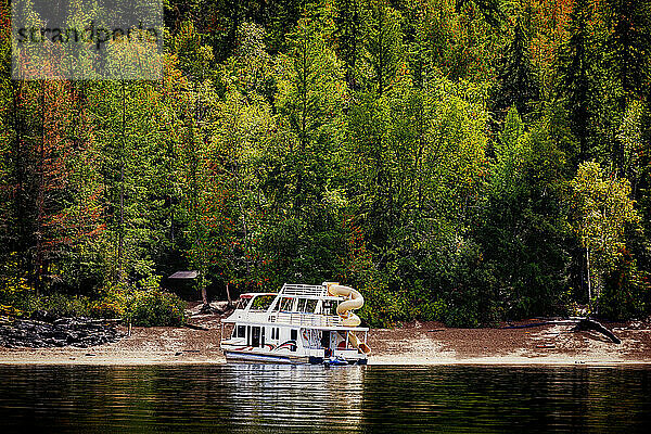 Ein Ferienhausboot  das im Herbst am Ufer des Shuswap Lake geparkt ist; Shuswap Lake  British Columbia  Kanada