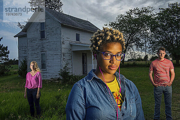 Drei junge Erwachsene stehen vor einem alten Bauernhaus; Bennet  Nebraska  Vereinigte Staaten von Amerika