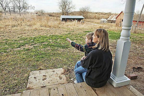 Mutter sitzt auf der Veranda eines Bauernhauses und hält ihren kleinen Sohn; Dunbar  Nebraska  Vereinigte Staaten von Amerika