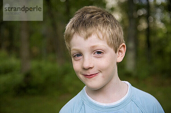 Außenporträt eines kleinen Jungen mit blonden Haaren und blauen Augen; Crosslake  Minnesota  Vereinigte Staaten von Amerika