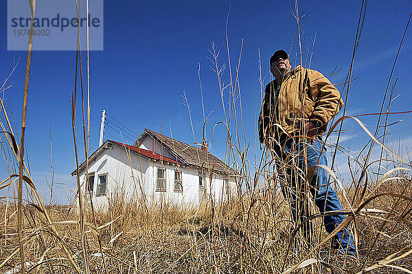 Mann erkundet ein verlassenes Schulhaus mit nur einem Raum in den Nebraska Sandhills  USA; Sandhills  Nebraska  Vereinigte Staaten von Amerika