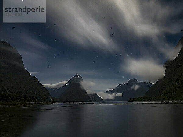 Mondbeschienener Nachthimmel und Wolken über dem Mitre Peak am Ufer des Milford Sound; Südinsel  Neuseeland